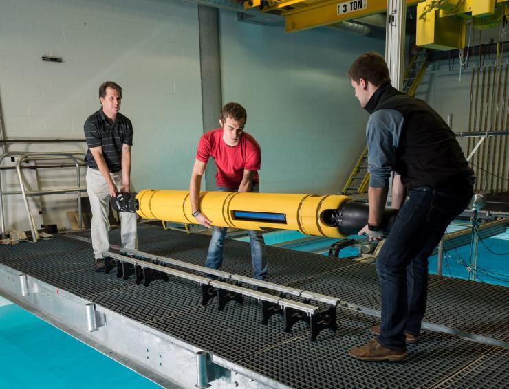 <p>GTRI principal research engineer Mick West, graduate student Jacob Buffo of the School of Earth and Atmospheric Sciences, and undergraduate Matthew Meister of the School of Mechanical Engineering handle the 210-pound Icefin at Georgia Tech’s Underwater Acoustics Research Laboratory.</p>