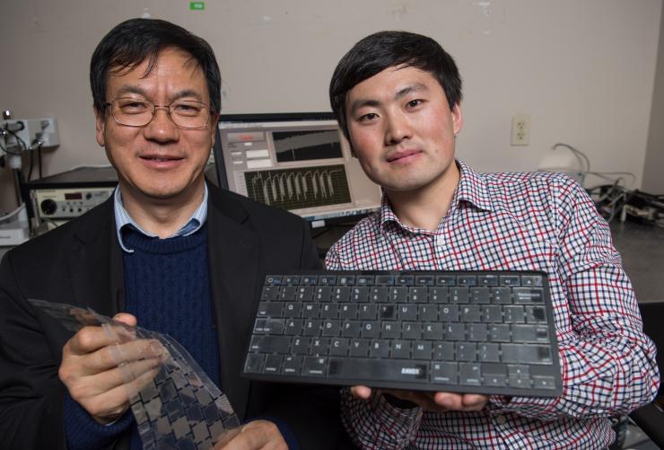 <p>Georgia Tech Professor Zhong Lin Wang (left) and graduate research assistant Jun Chen display their new self-powered keyboard. The device could provide a stronger layer of security for computer users. (Credit: Rob Felt)</p>