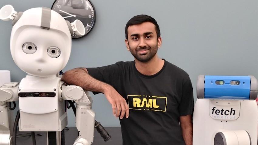 Robotics Ph.D. student Kartik Ramachandruni posing with a robot in a Georgia Tech lab.