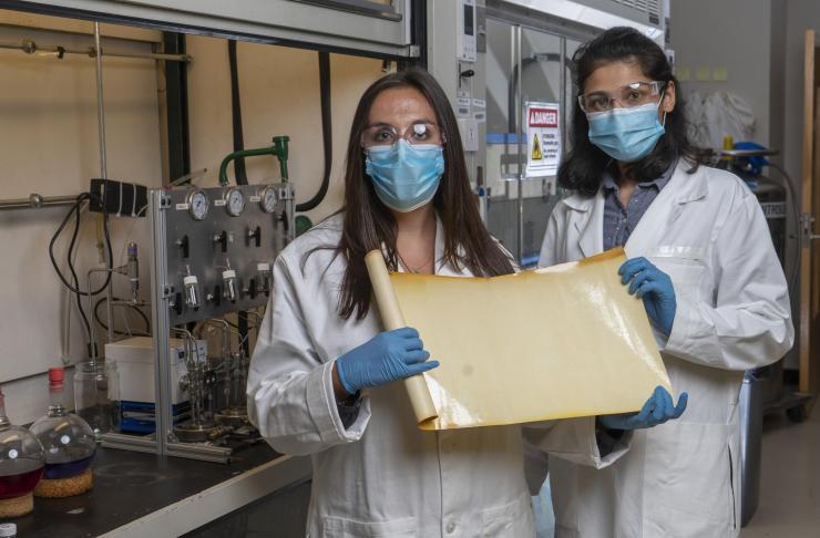 Georgia Tech graduate research assistants Kirstie Thompson and Ronita Mathias with a sample of a new membrane material that could reduce carbon emissions and energy intensity associated with refining crude oil. (Credit: Christopher Moore, Georgia Tech)