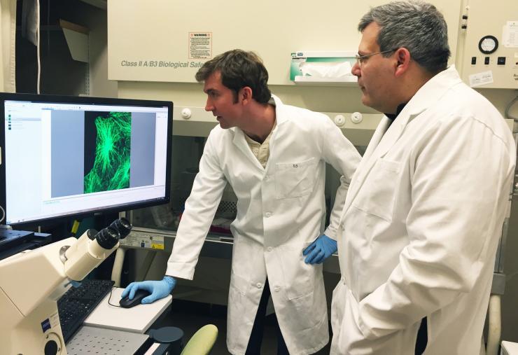 <p>Researchers Phil Santangelo and Eric Alonas with a spinning disk confocal microscope used to image cells. Santangelo is a professor in the Wallace H. Coulter Department of Biomedical Engineering at Georgia Tech and Emory University; Alonas is a Georgia Tech graduate student. (Credit: John Toon, Georgia Tech)</p>