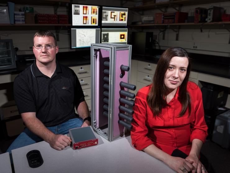 <p>Georgia Tech Graduate Student Paul Rose and Assistant Professor Anna Erickson are shown with Cherenkov quartz detectors that would be used to image shielded radioactive materials inside cargo containers. (Credit: Rob Felt, Georgia Tech)</p>