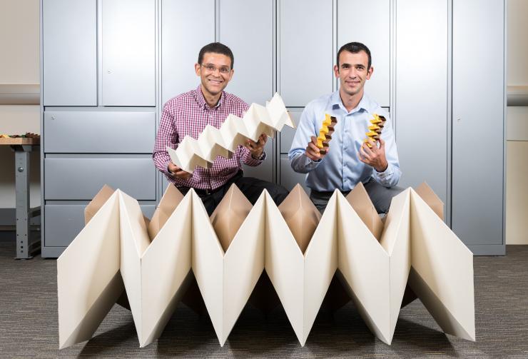 <p>Researchers Glaucio Paulino (left) and Evgueni Filipov with three origami structures showing the size flexibility of the "zippered tube" system. Filipov is from University of Illinois at Urbana-Champaign; Paulino is from the Georgia Institute of Technology. (Credit: Rob Felt, Georgia Tech) </p>