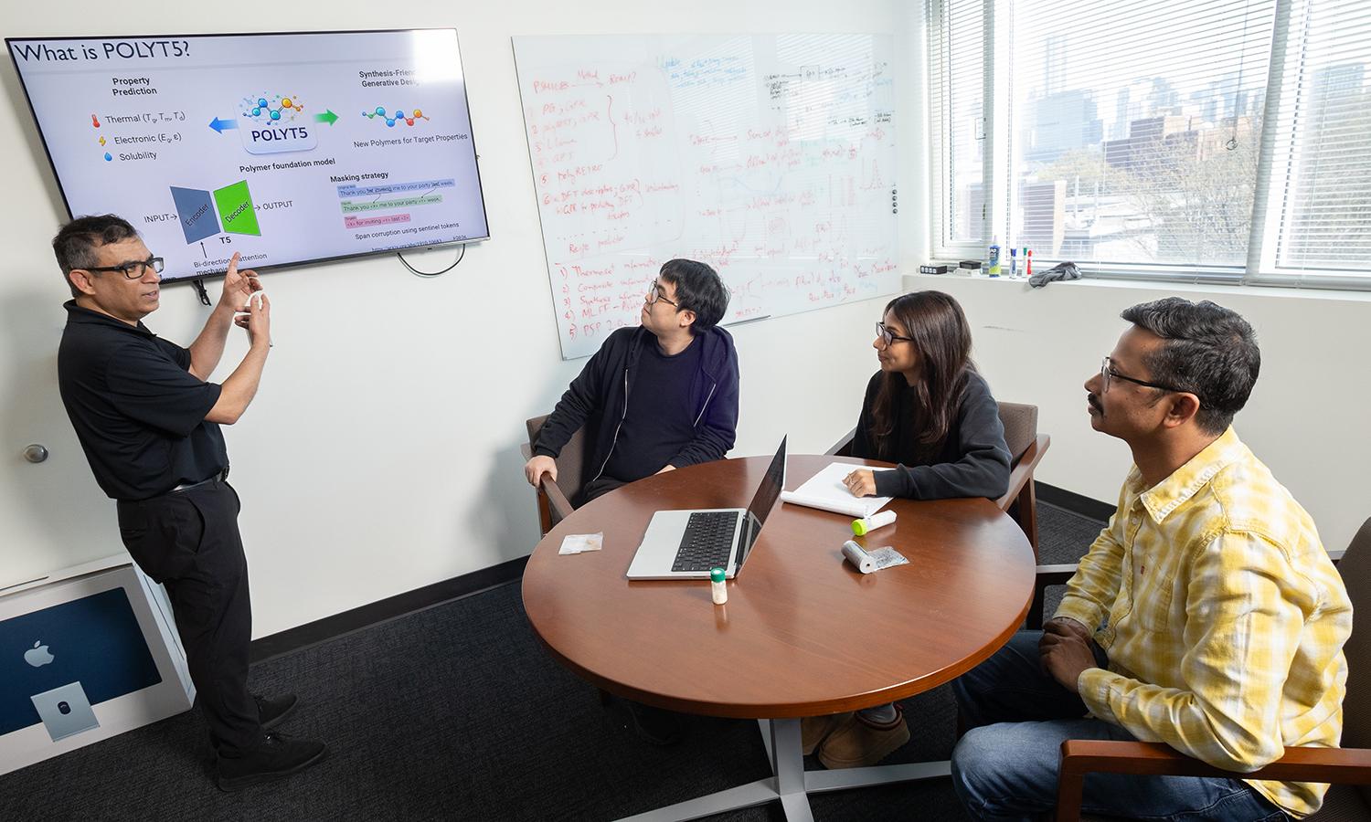 Rampi Ramprasad and three members of his research team discuss their AI model for generative polymer design in his office.