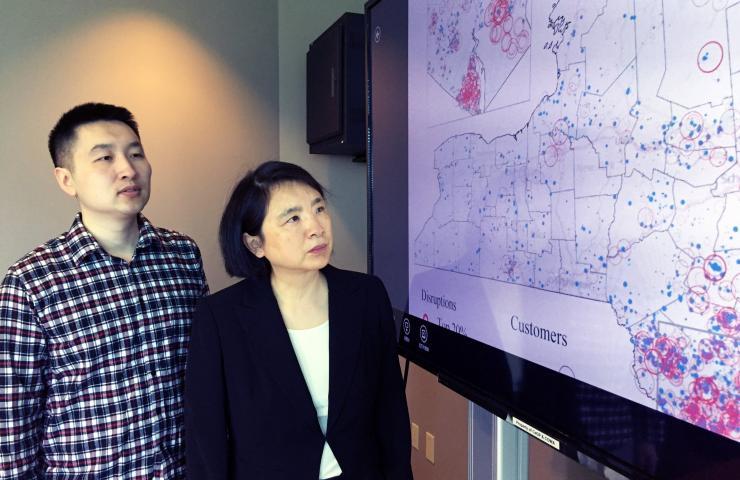 <p>Georgia Tech Ph.D. student Yun Wei and Associate Professor Chuanyi Ji with a map showing utility disruptions in New York State resulting from Super Storm Sandy. (Credit: John Toon, Georgia Tech)</p>