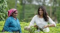 women in green field with one holding a basket