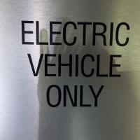 Drivers of electric vehicles look for signs like this one to indicate the location of charging stations.