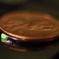 A millimeter-scale structure with submicron features is supported on a U.S. penny on top of a reflective surface. (Credit: Vu Nguyen and Sourabh Saha)
