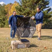 GTRI Senior Research Engineer Aharon Karon (left) and Research Engineer Aprameya Satish prepare to place an infrasound detection device under a small wind cover during a field test. (Credit: Christopher Moore, GTRI).