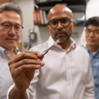 <p>Seung Soon Jang, an associate professor, Faisal Alamgir, an associate professor, and Ji Il Choi, a postdoctoral researcher, all in Georgia Tech’s School of Materials Science and Engineering, examine a piece of platinum-graphene catalyst. (Credit: Allison Carter)</p>