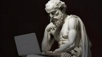 AI-generated image of Socrates, sculpted in marble, looking contemplatively at a laptop.