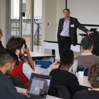 <p>Chris Rozell addresses the room during the Intelligent Interactions with the Brain (I2B) Workshop.</p>