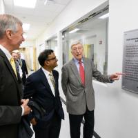 <p>A plaque is unveiled in the new Good Manufacturing Practice (GMP) like facility that is part of the Marcus Center for Therapeutic Cell Characterization and Manufacturing (MC3M). Shown are Georgia Tech President G.P. “Bud” Peterson, Center Director Krishnendu Roy, and philanthropist Bernie Marcus. (Credit: Rob Felt, Georgia Tech)</p>