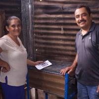 <p>Residents of Nuevo Amanecer in Nicaragua stand with their new clean cookstove, installed in 2019. Credit: Engineers Without Borders</p>