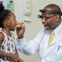 <p>Georgia CTSA investigator Charles E. Moore, MD, professor at the Emory University School of Medicine, examines a young patient.</p>