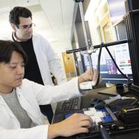 <p>Associate Professor Costas Arvanitis and mechanical engineering Ph.D. student Hohyun "Henry" Lee with their closed-loop controlled focused ultrasound system. The uses ultrasound-induced microbubbles to help a powerful immunotherapy target brain tumors and a custom algorithm to continuously fine tune the bubbles for maximum impact.</p>