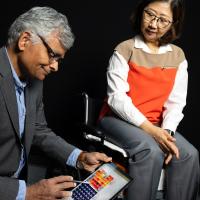   Sundaresan Jayaraman (left) looks at pressure data from fabric sensors he developed with Sungmee Park, who is seated in their prototype wheelchair system. (Photo: Candler Hobbs)