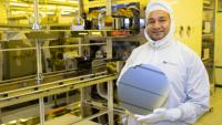 Asif Khan holds a silicon wafer in a cleanroom.