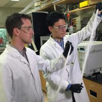 <p>Georgia Tech Assistant Professor Ryan Lively (left) and Postdoctoral Fellow Dong-Yeun Koh hold bundles of hollow polymer fibers that serve as precursors for the carbon membrane fiber used to separate alkyl aromatic chemicals. (Credit: John Toon, Georgia Tech)</p>