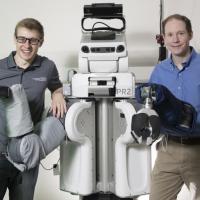 <p>A PR2 robot puts a hospital gown on human arms after teaching itself how to do it.</p>