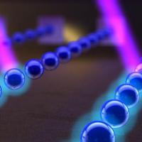 <p>Atoms, here in blue, shoot out of parallel barrels of an atom beam collimator. Lasers, here in pink, can manipulate the exiting atoms for desired effects. Credit: Georgia Tech / Ella Maru studios work for hire</p>