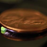 <p>A millimeter-scale structure with submicron features is supported on a U.S. penny on top of a reflective surface. (Credit: Vu Nguyen and Sourabh Saha)</p>
