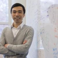 <p>CSE Associate Professor Polo Chau stands in front of a white board with equations written on it.</p>