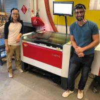 <p>To help meet the need for personal protective equipment (PPE) for health care workers, Georgia Tech has designed and is producing face shields. Shown is a laser cutting machine used to create frames for the shields.</p>
