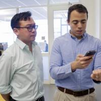 <p>Graduate student Rob Mannino (right), pictured with Wilbur Lam (left), looks at his own fingernails using the new anemia test app. Credit: Georgia Tech / Christopher Moore</p>