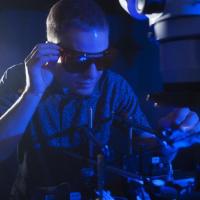 <p>NSF Graduate Research Fellow Erik Anderson tests the conversion of blue light to electricity with a new higher efficiency rectenna design. (Credit: Christopher Moore, Georgia Tech)</p>