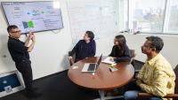 Rampi Ramprasad and three members of his research team discuss their AI model for generative polymer design in his office.
