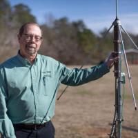 <p>John Trostel, director of the Severe Storms Research Center (SSRC), poses with a sensor that is part of the North Georgia Lightning Mapping Array, a network of 12 such sensors located around the metropolitan Atlanta area to detect lightning that may indicate storm intensification. (Credit: Branden Camp, Georgia Tech Research Institute)</p>
