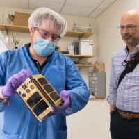 <p>Georgia Tech aerospace engineering graduate student Byron Davis shows Xenesis CEO Mark LaPenna one of the RANGE CubeSats scheduled to go into orbit later this fall. (Credit: Allison Carter, Georgia Tech)</p>